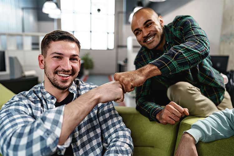 Two men smiling and fist bumping while in Intensive Outpatient Program (IOP).