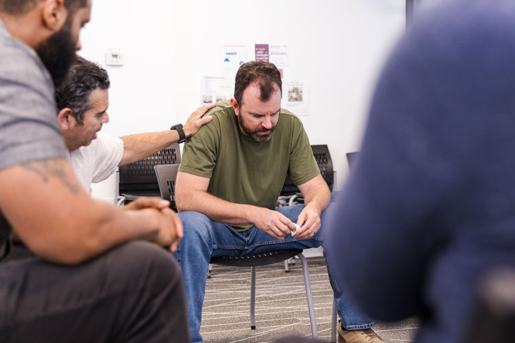 Photos of a man with head down going through continued outpatient treatment.