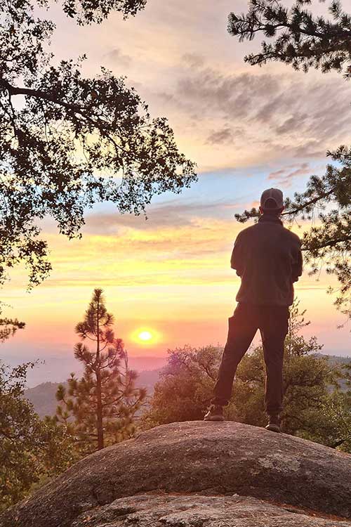 Man standing on rock overlooking vista with sunset in sedative addiction treatment for Men in Vista, CA.
