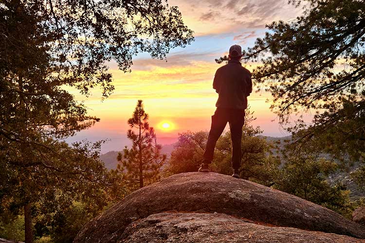 Man standing on rock overlooking vista with sunset in sedative addiction treatment for Men in Vista, CA.