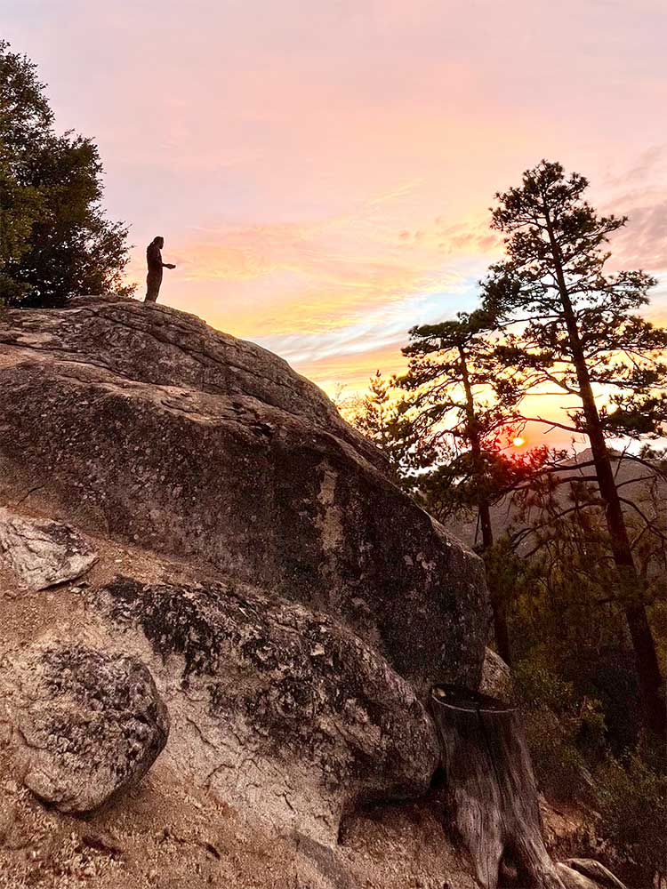 Man standing on cliff side enjoying view as part of his wilderness therapy to overcome addiction.