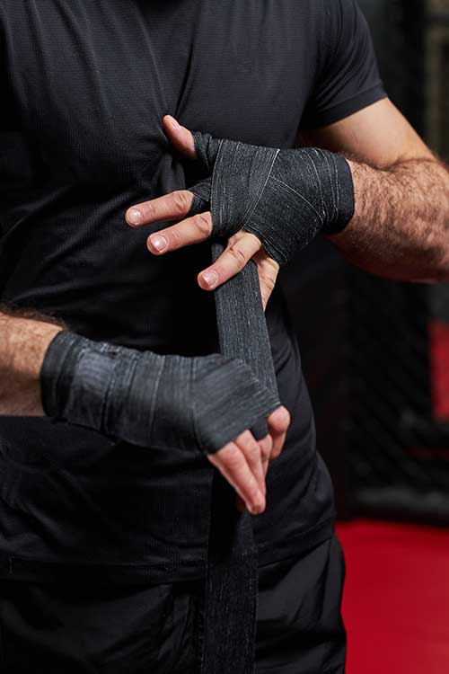 Man wrapping hands with tape preparing for Jujitsu as part of addiction therapy in Vista, CA.