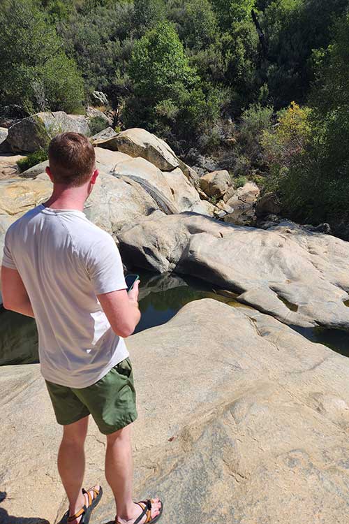Man standing on rock outside during hike for stimulant addiction treatment in Vista, CA.