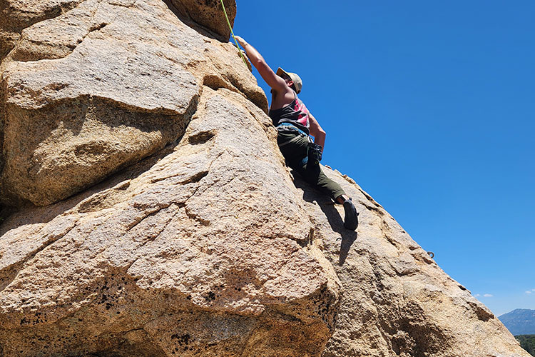 Man on cliff side as part of rock climbing for partial hospitalization addiction treatment (PHP) in Vista, CA.