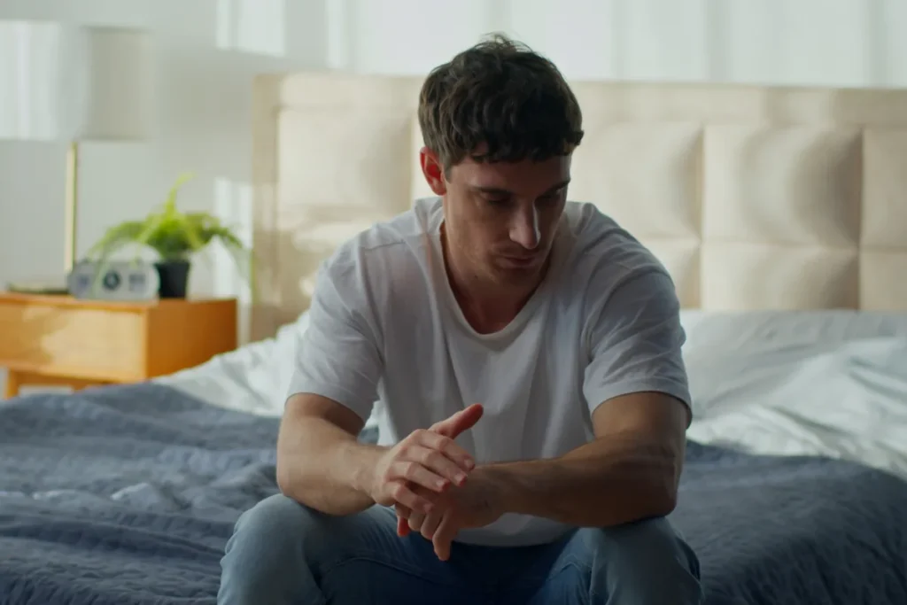 man sitting on bed thinking about how he can safely undergo polysubstance detox for his alcohol, benzo, and stimulant use